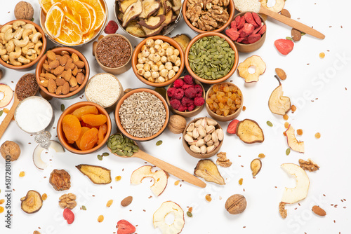 Healthy vegetarian food concept. Assortment of dried fruits, nuts and seeds on white background. Top view. Mixed nuts set closeup.