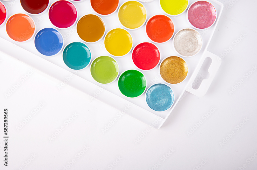 Box with watercolor paint on white background, background. Equipment for a creative hobby - drawing. Box with watercolor paint on white background, background. Equipment for a creative hobby - drawing.