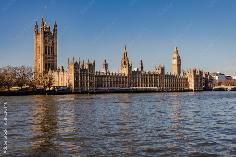 Big Ben and the River Thames with a blue sky and warm sunshine
