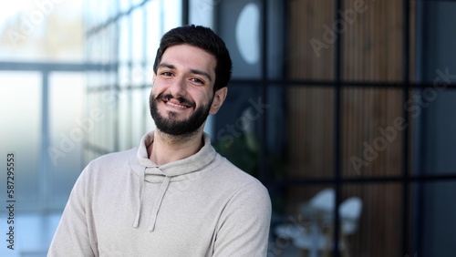 Portrait of handsome young male entrepreneur posing in office co