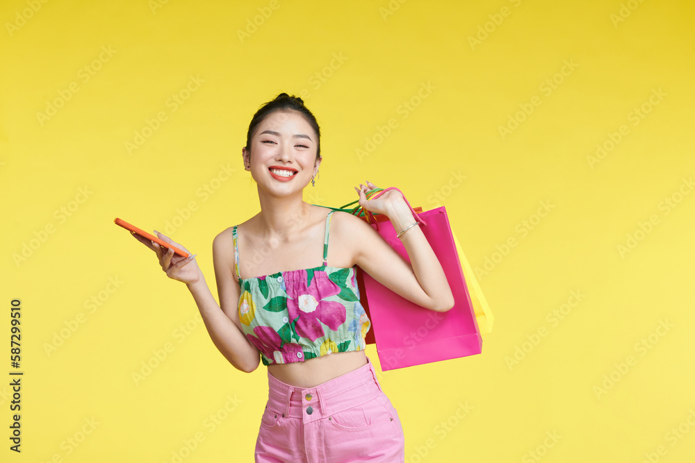 young woman holding shopping bags and smart phone young woman holding shopping bags and smart phone
