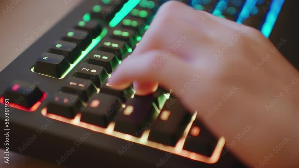 Player Uses Gaming Keyboard. Hands Young Gamer Plays Video Game Close up Typing on Computer Keyboard in Neon Lighting. Guy teenager Working Night. Concept Cyberspace. Top view Player Uses Gaming Keyboard. Hands Young Gamer Plays Video Game Close up Typing on Computer Keyboard in Neon Lighting. Guy teenager Working Night. Concept Cyberspace. Top view
