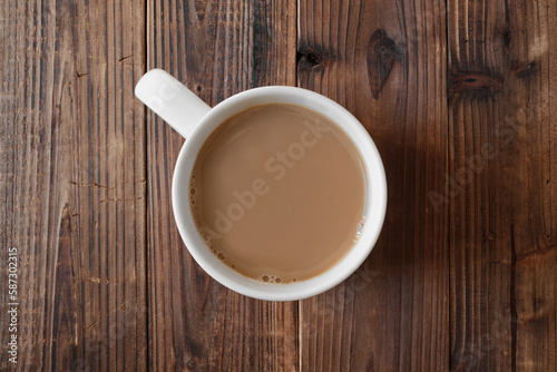 Cup of coffee on rustic wood. Overhead view.