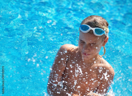 Teenage fun in swimming pool with splashing water.