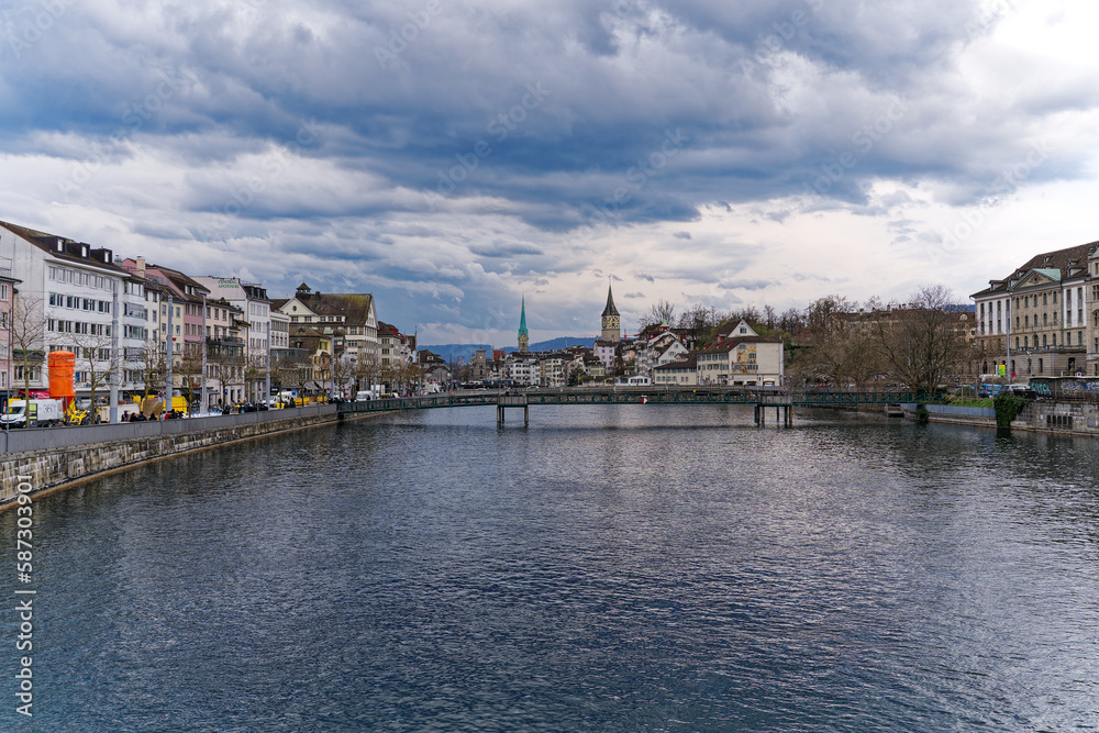 Scenic view of the old town of City of Zürich with Limmat River, quayside and footbridge on a cloudy spring day. Photo taken March 31st, 2023, Zurich, Switzerland.