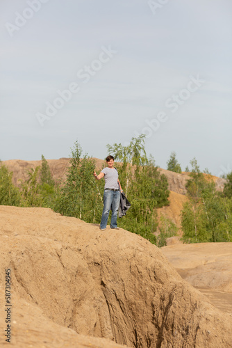 A woman stands on a hill and gestures