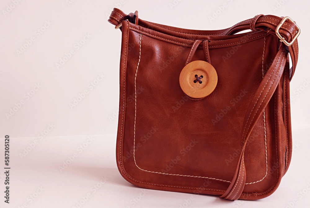 Ladies' leather handbag, a dark brown color with shoulder strap on the white background.