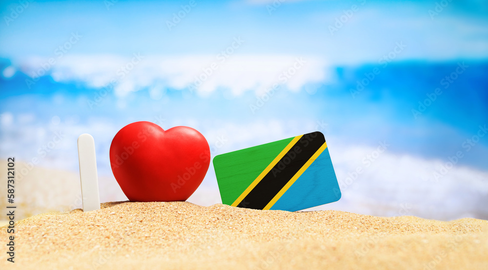 I love Tanzania and Zanzibar. Flag of Tanzania on the beach with a red heart. vacation and travel concept. I love Tanzania and Zanzibar. Flag of Tanzania on the beach with a red heart. vacation and travel concept.