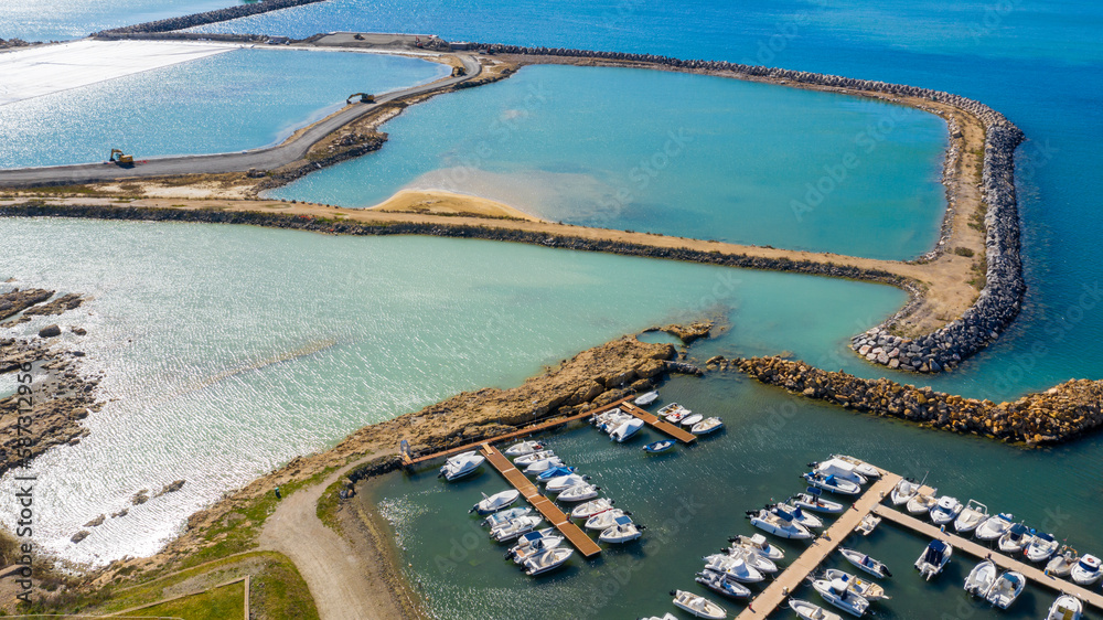 Aerial view of Mattonara and Buca di Nerone, an archaeological area located in Civitavecchia near Rome, Italy. The area has been affected by marine erosion. There is a marina with many boats.