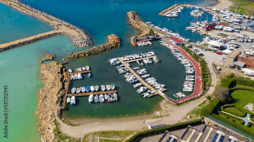 Aerial view of Mattonara and Buca di Nerone, an archaeological area located in Civitavecchia near Rome, Italy. The area has been affected by marine erosion. There is a marina with many boats. photo