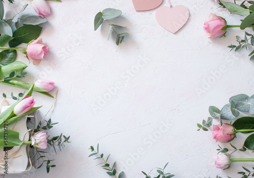 Wedding arrangement of pink spring flowers with heart shape on white background. Top view  flat lay. Flower frame in boho style for a seasonal wedding concept or mother s day greetings with space for 