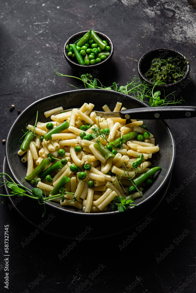 Pasta with green peas and green beans in a bowl