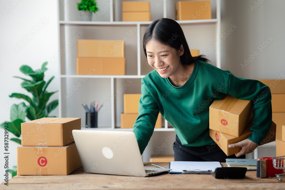 The owner of an online store is checking orders for packaged products in order to prepare them for delivery to customers as ordered through the website. Online selling and online shopping concepts. The owner of an online store is checking orders for packaged products in order to prepare them for delivery to customers as ordered through the website. Online selling and online shopping concepts.