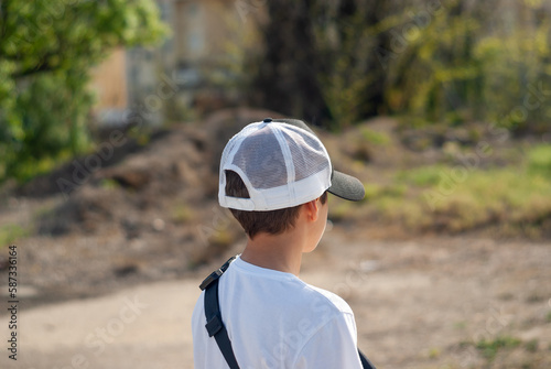 Niño con gorra de béisbol desde atrás.