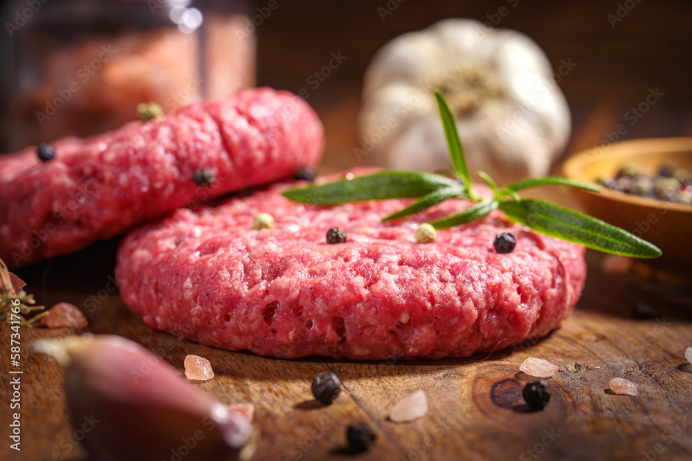 Stek z mięsa mielonego do hamburgera z przyprawami, cebula, papryka na starych deskach Stek z mięsa mielonego do hamburgera z przyprawami, cebula, papryka na starych deskach