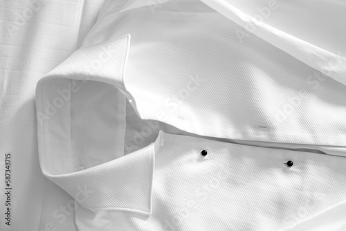 dettaglio di una bella camicia bianca distesa sul letto  photo