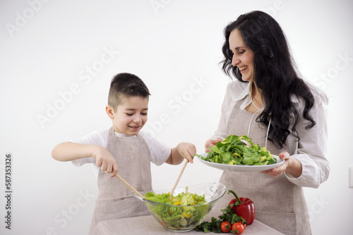 family, cooking and people concept happy mother and little son with molds making cookies from dough on a white background