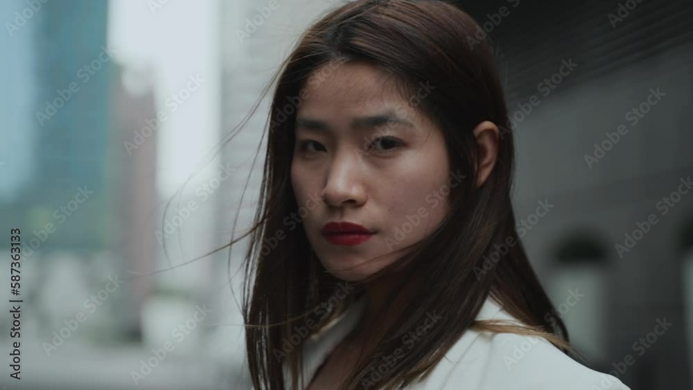 Chinese women stand and stare at the camera in Chengdu China, woman's face was expressionless,breeze blowing her hair