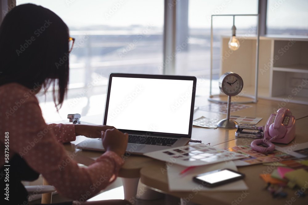 Businesswoman working on laptop at office desk Businesswoman working on laptop at office desk