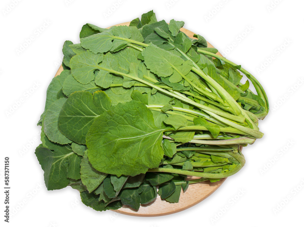 Rapeseed(canola) leafy vegetables on a round wooden cutting board on a white background with clipping path. Rapeseed(canola) leafy vegetables on a round wooden cutting board on a white background with clipping path.