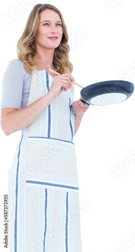 Smiling woman holding frying pan and wooden spoon 