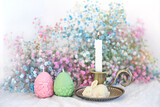 decorative Easter bunny, eggs and candlestick, gentle colorful flowers close up on blurred light background. Easter holiday, Ostara concept. festive composition for spring season. greeting card design