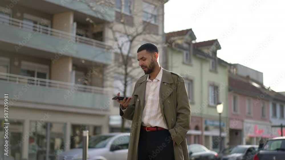One pensive Middle Eastern man standing in street holding phone in deep thought expression. A thoughtful Middle Eastern pondering decision and using technology One pensive Middle Eastern man standing in street holding phone in deep thought expression. A thoughtful Middle Eastern pondering decision and using technology