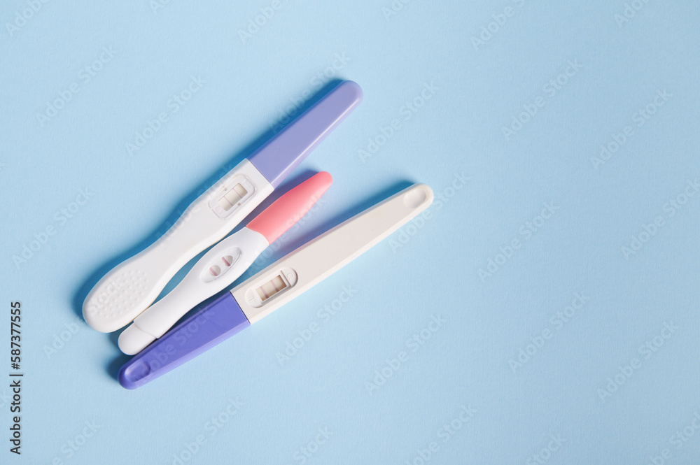 Rapid diagnosis of pregnancy at home. Pregnancy test kits with two bars on isolated blue pastel background. Copy ad space. Women's health, gynecology and medicine concept. Planning maternity concept