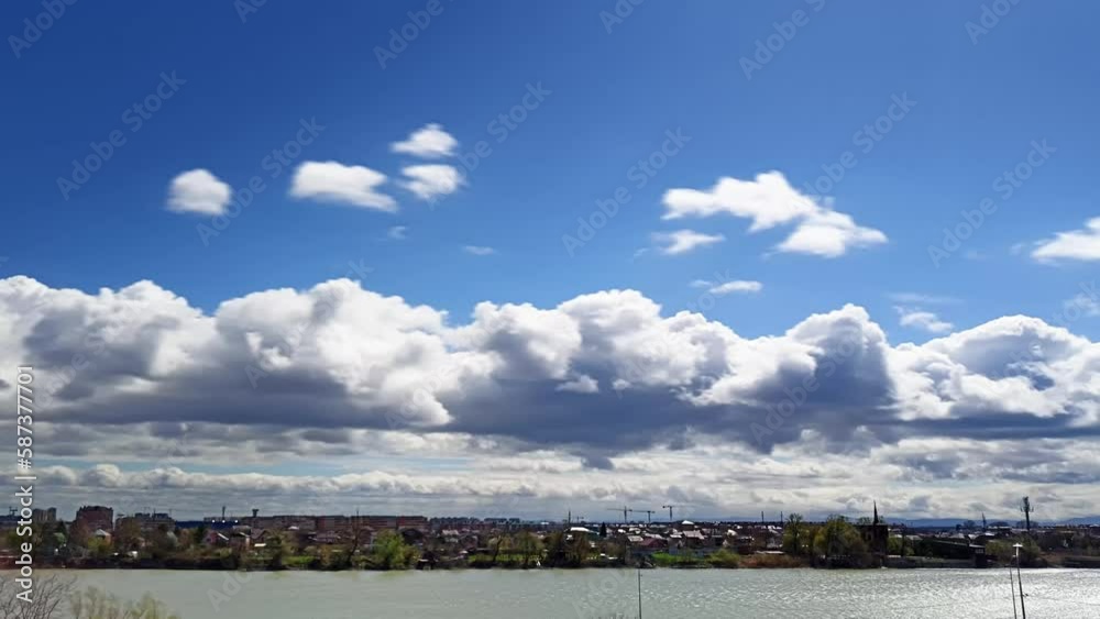 beautiful cumulus clouds flying over the Kuban River near the city of Krasnodar on a sunny day in early spring. Caucasus mountains on the horizon. Timelapse 1 to 60 beautiful cumulus clouds flying over the Kuban River near the city of Krasnodar on a sunny day in early spring. Caucasus mountains on the horizon. Timelapse 1 to 60