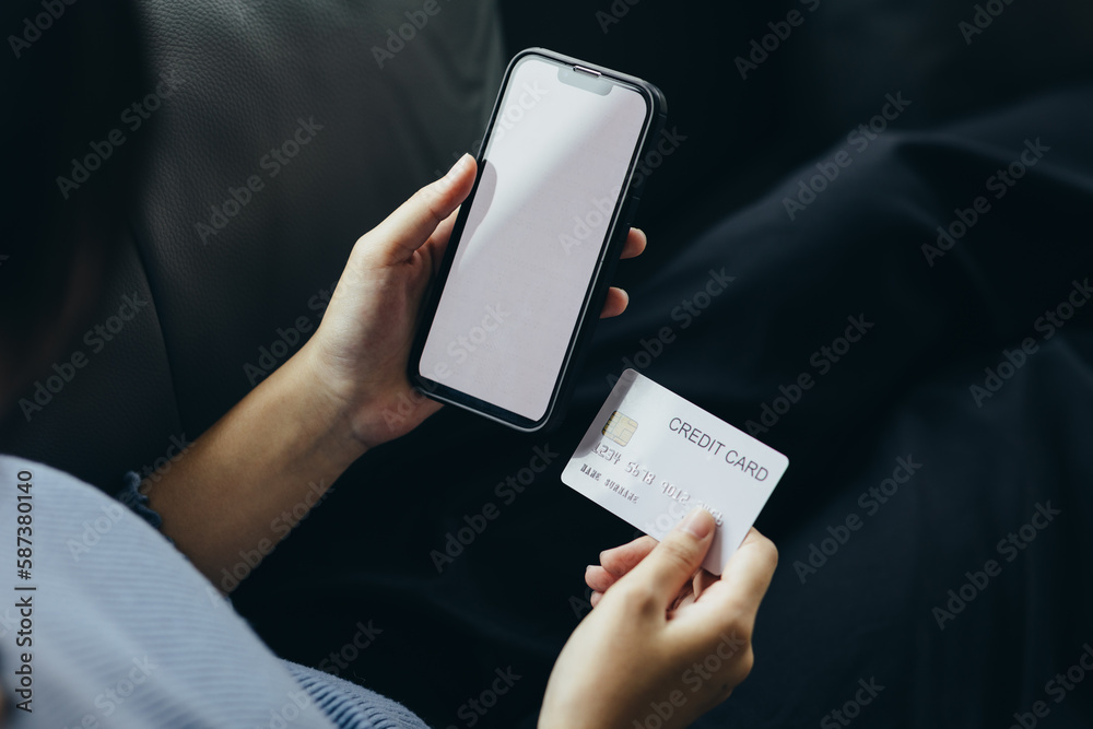 Close up of young woman holding credit card using smartphone online payment, home shopping, ecommerce, internet banking, spend money, finance, e-shop concept. Close up of young woman holding credit card using smartphone online payment, home shopping, ecommerce, internet banking, spend money, finance, e-shop concept.