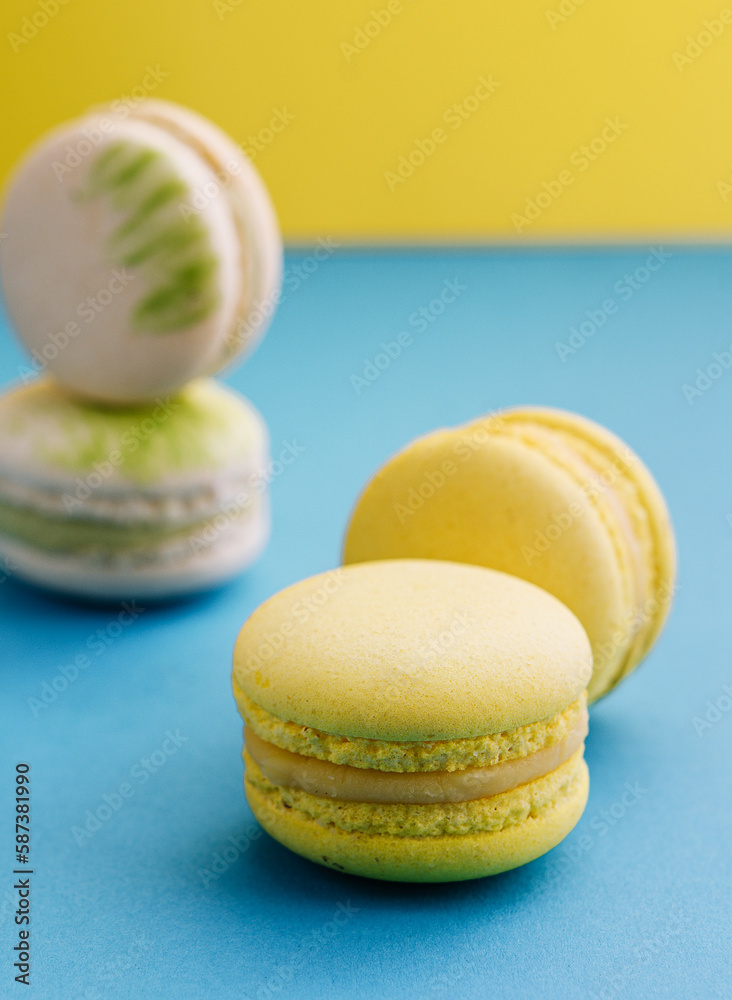 Sweet and colorful macaroons on blue with yellow background Sweet and colorful macaroons on blue with yellow background
