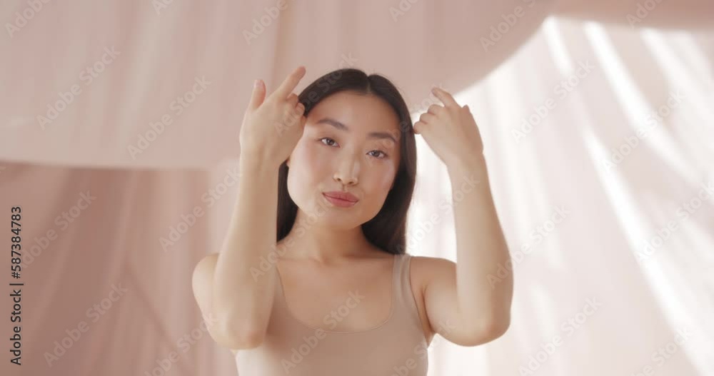 Asian woman touching clean face and admiring healthy, soft skin. Pretty model having happy, smiling and posing to camera. Showing natural beauty face. Beautiful view, good looking. Asian woman touching clean face and admiring healthy, soft skin. Pretty model having happy, smiling and posing to camera. Showing natural beauty face. Beautiful view, good looking.