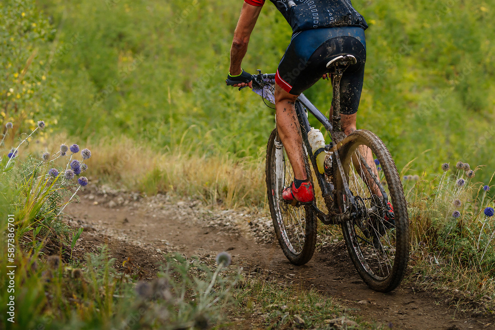 Obraz premium male mountain bike cyclist riding on cross-country cycling, dirty drops on bike and clothes, race in cloudy trail