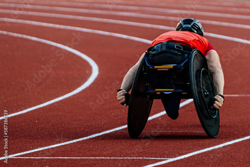 male athlete in wheelchair racing red track stadium in para athletics competition, summer sports games