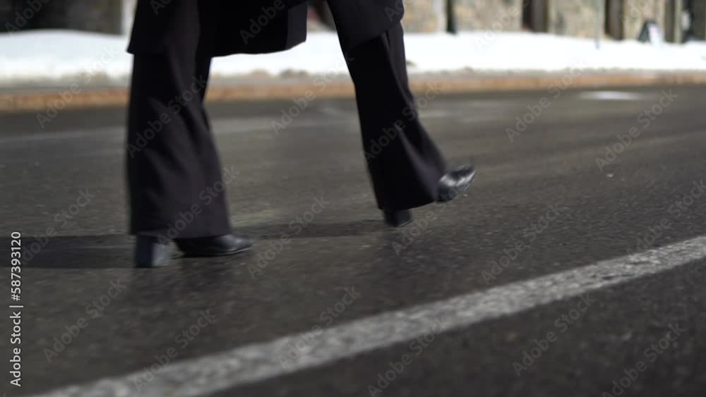 Close up details female legs wearing high-heels shoes walking on the road in urban modern city. slow motion Close up details female legs wearing high-heels shoes walking on the road in urban modern city. slow motion
