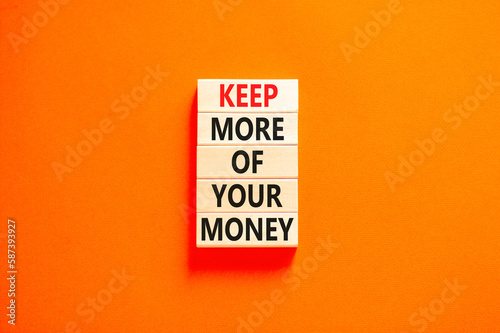 Keep more of your money symbol. Concept words Keep more of your money on wooden block. Beautiful orange table orange background. Business keep more of your money concept. Copy space.