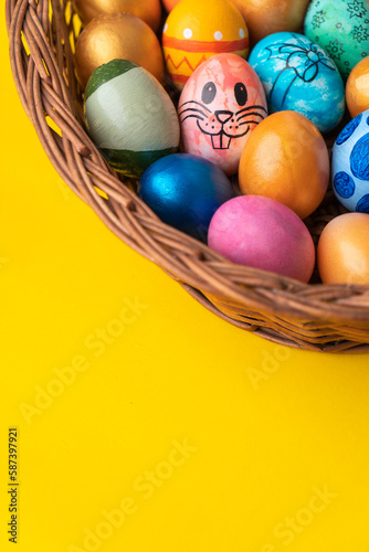 Colourful easter eggs on the basket with copy space for greeting text, 2023 creative easter background