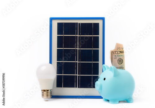 Solar panel, led lamp, house model, money and piggy bank isolated on white background. The concept of saving money and clean energy. Concept of ecology and sustainable development. photo