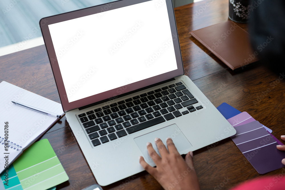 Cropped hand of woman using laptop at home Cropped hand of woman using laptop at home