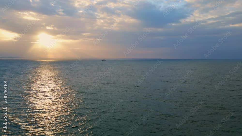 Aerial breathtaking ocean sunrise with lonely boat floating on gloomy horizon. Aerial breathtaking ocean sunrise with lonely boat floating on gloomy horizon.