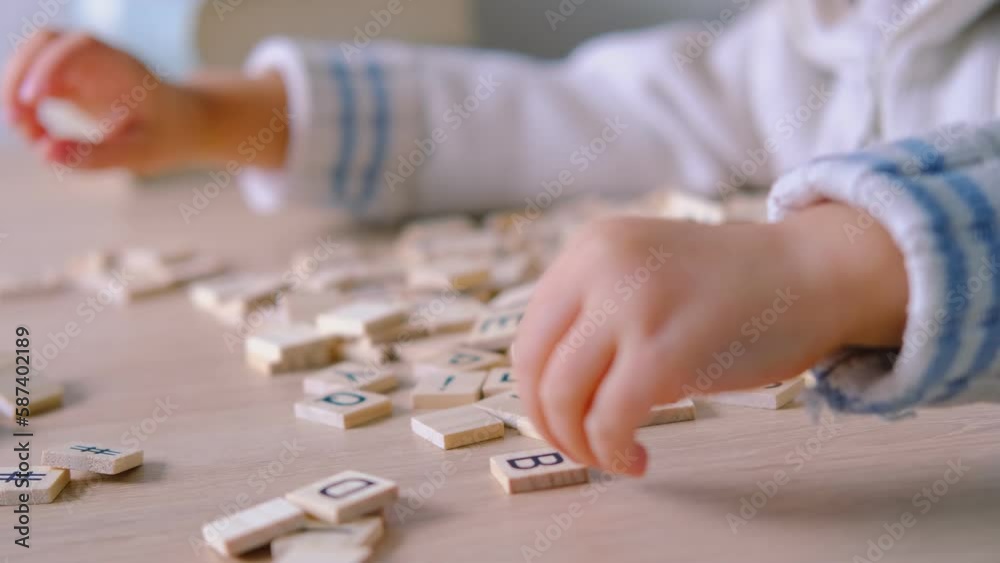 hands close-up, small child 3 years old plays wooden alphabet blocks, makes up words from letters, dyslexia awareness, learning difficulties, human brain development, happy childhood, selective focus hands close-up, small child 3 years old plays wooden alphabet blocks, makes up words from letters, dyslexia awareness, learning difficulties, human brain development, happy childhood, selective focus