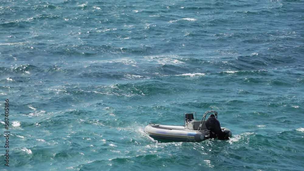 Inflatable emergency rescue motor boat swing on sea waves Inflatable emergency rescue motor boat swing on sea waves