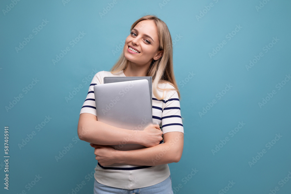 successful confident young woman student with a laptop in her hands on a blue isolated background successful confident young woman student with a laptop in her hands on a blue isolated background