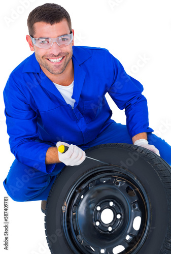 Portrait of happy mechanic working on tire © vectorfusionart