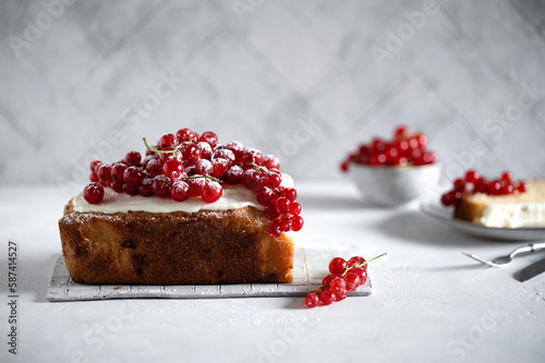 Red currant loaf cake decorated with cream and fresh healthy berries on a light background. 