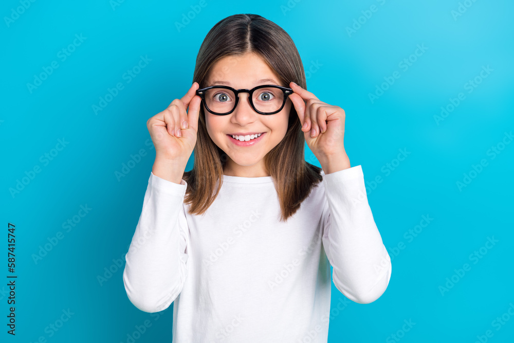 Photo of impressed girl with long hairstyle wear white long sleeve fingers touch glasses staring isolated on blue color background Photo of impressed girl with long hairstyle wear white long sleeve fingers touch glasses staring isolated on blue color background