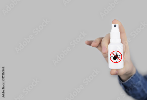Tick repellant. Insect protection. Girl holds a spray on a white background that will protect against ticks. Repelling blood-sucking insects.