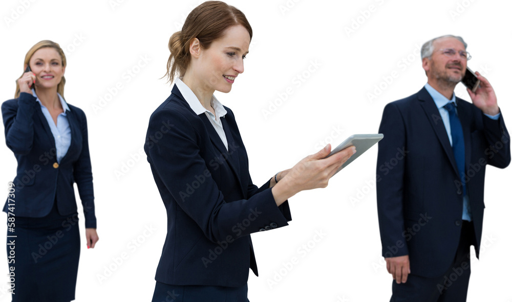 Businesswoman using tablet while colleagues talking on phone Businesswoman using tablet while colleagues talking on phone