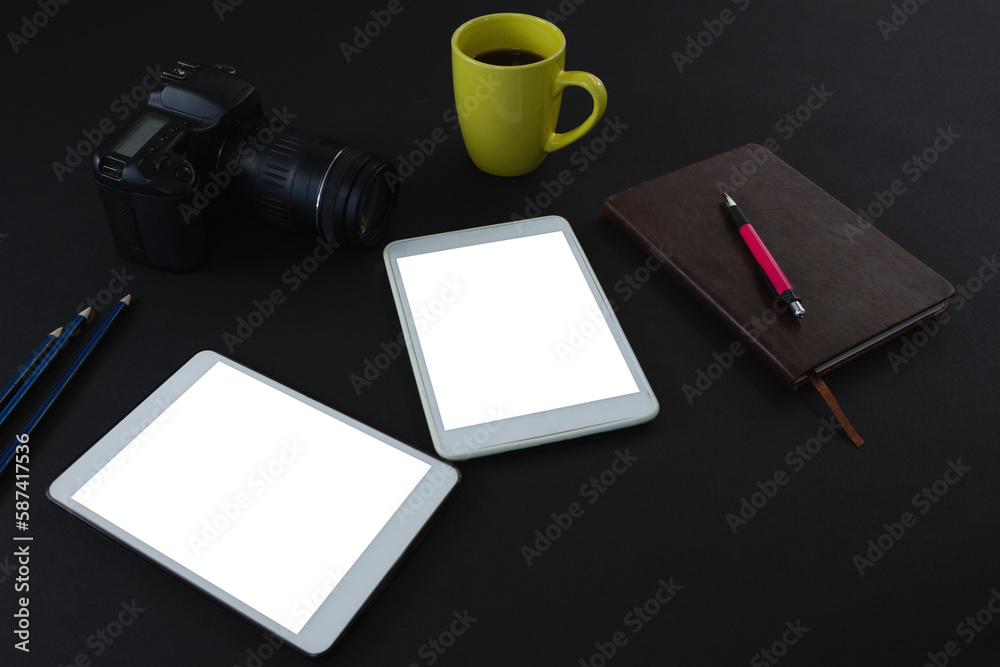 Digital tablet, black coffee, camera, organizer and pen on black background Digital tablet, black coffee, camera, organizer and pen on black background