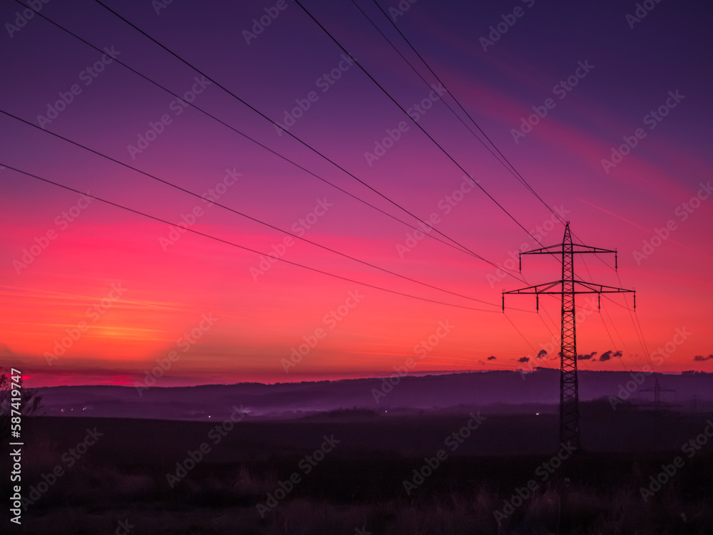 Fototapeta premium Electricity lines at dramatic sunset